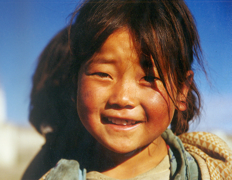 阳光下，这个小女孩展开纯金般的笑容，多么珍贵！或许她不能象别处的小孩那样生活优越，但是她已感到满足幸福，并且把它分享给阳光下的每一个人。